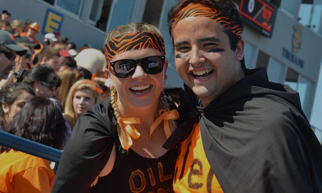 two students at a UF football game dressed up in orange and black